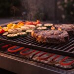 Primer plano de la parrilla de una barbacoa eléctrica con carne y verduras asándose sobre las barras de hierro fundido y la resistencia al rojo vivo debajo